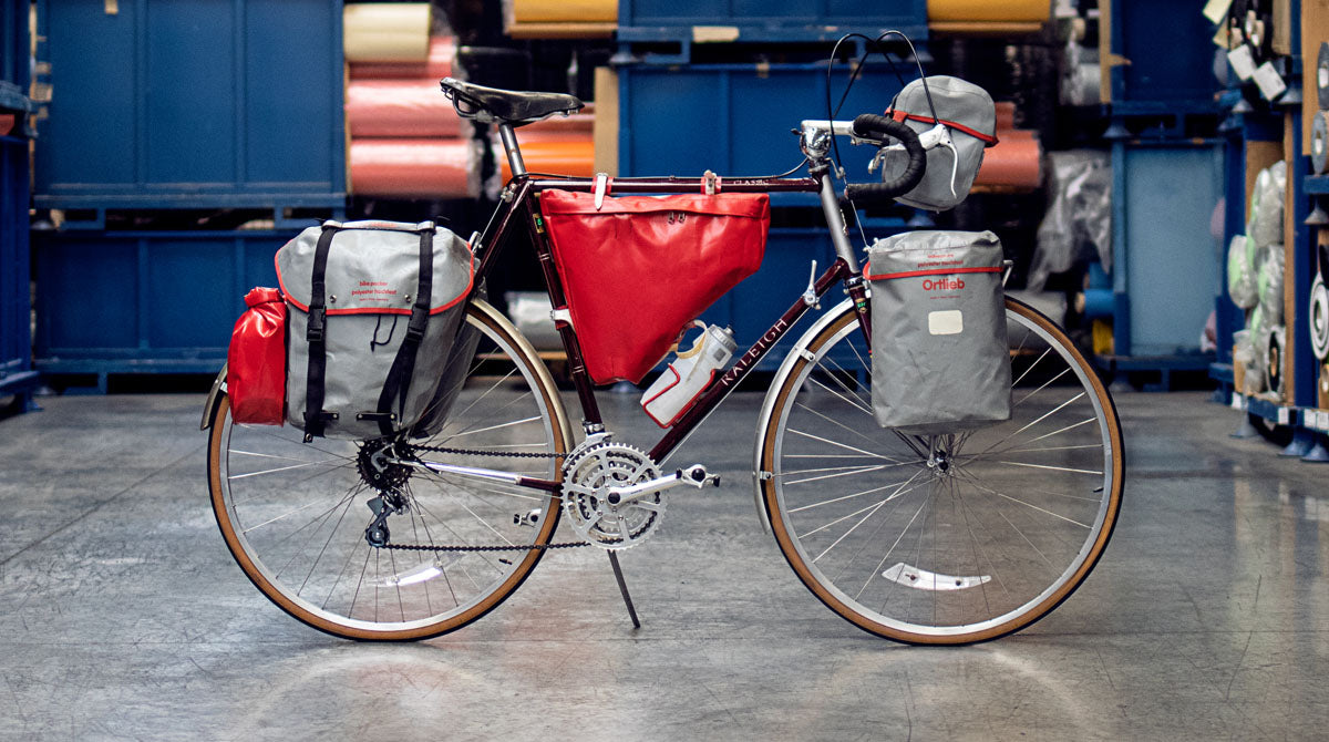 Tourenrad mit ORTLIEB-Taschen, geparkt in einem Lagerhaus.