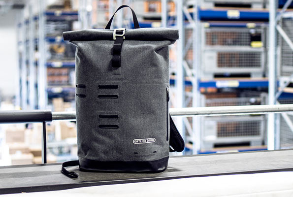 ORTLIEB Commuter Daypack in einem Lagerhaus, mit einem eleganten Rolltop-Design.